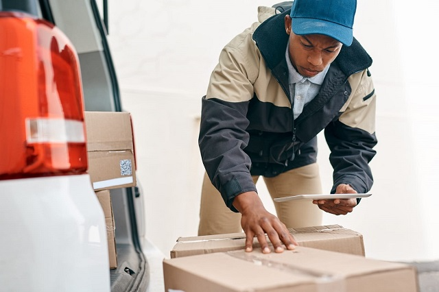 Delivery professional double-checking the delivery address on a package