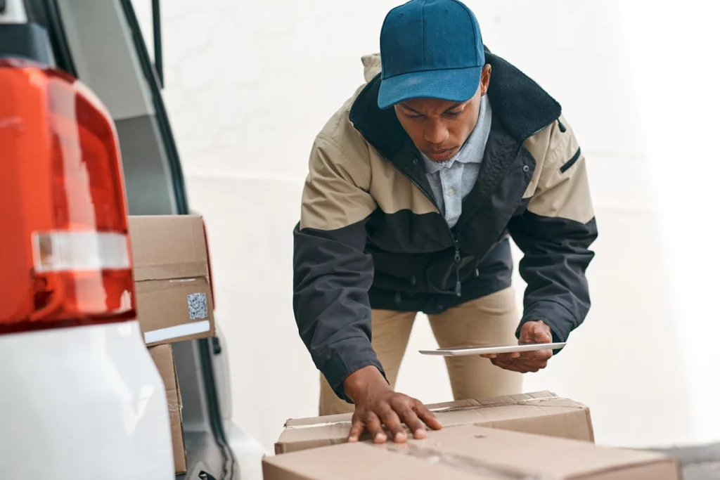 Delivery driver verifying address before delivering a package