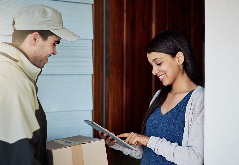 Customer signing a tablet digitally to confirm receiving a delivery