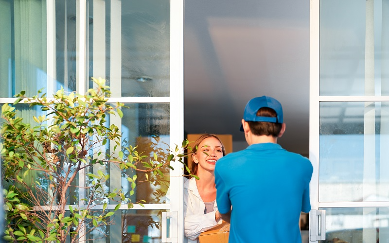 Customer in a rural area accepting packages from a delivery driver