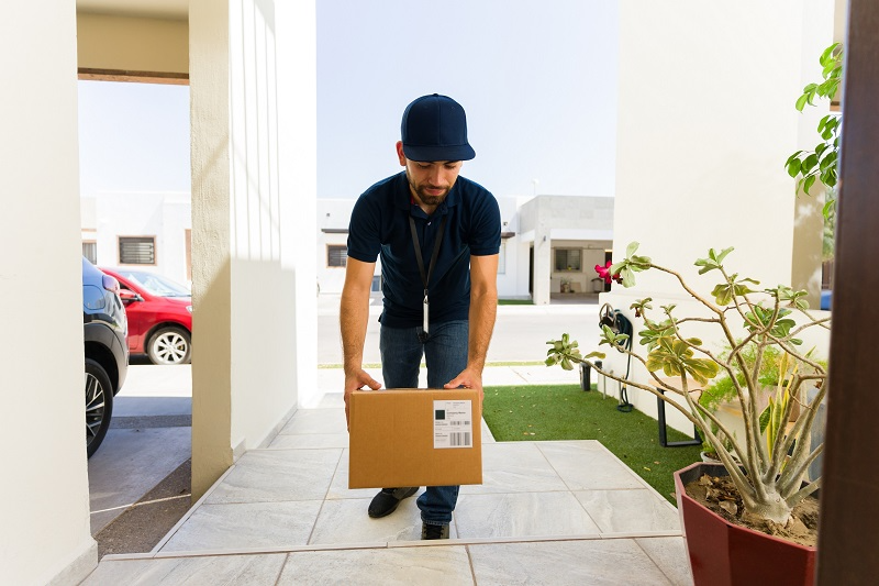 Delivery driver leaving a package at a customer's door