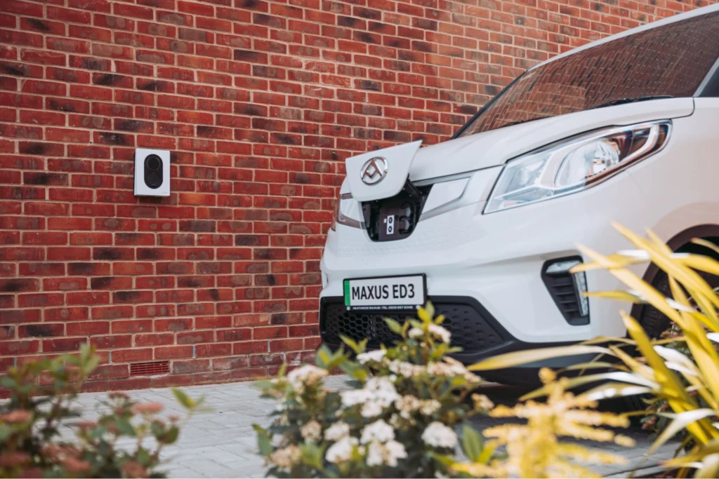 electrical vehicle in front of outlet on brick wall