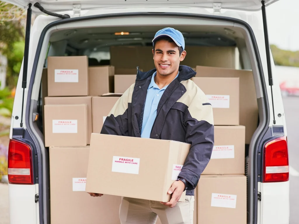 man carrying box at back of open truck