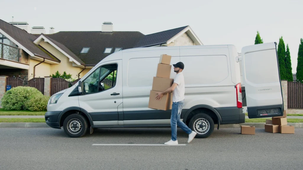 Driver carrying packages around a delivery van