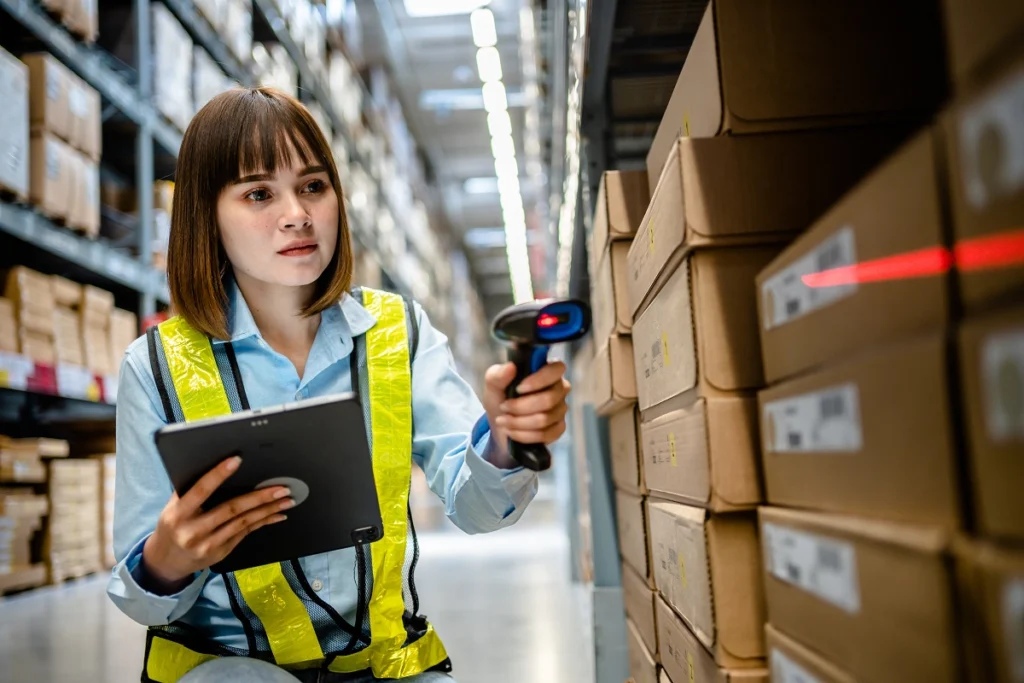 Using warehouse inventory management software on a tablet with a handheld barcode scanner