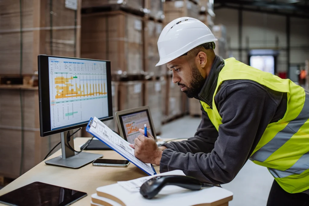 Manager using logistics management software in a warehouse or distribution center